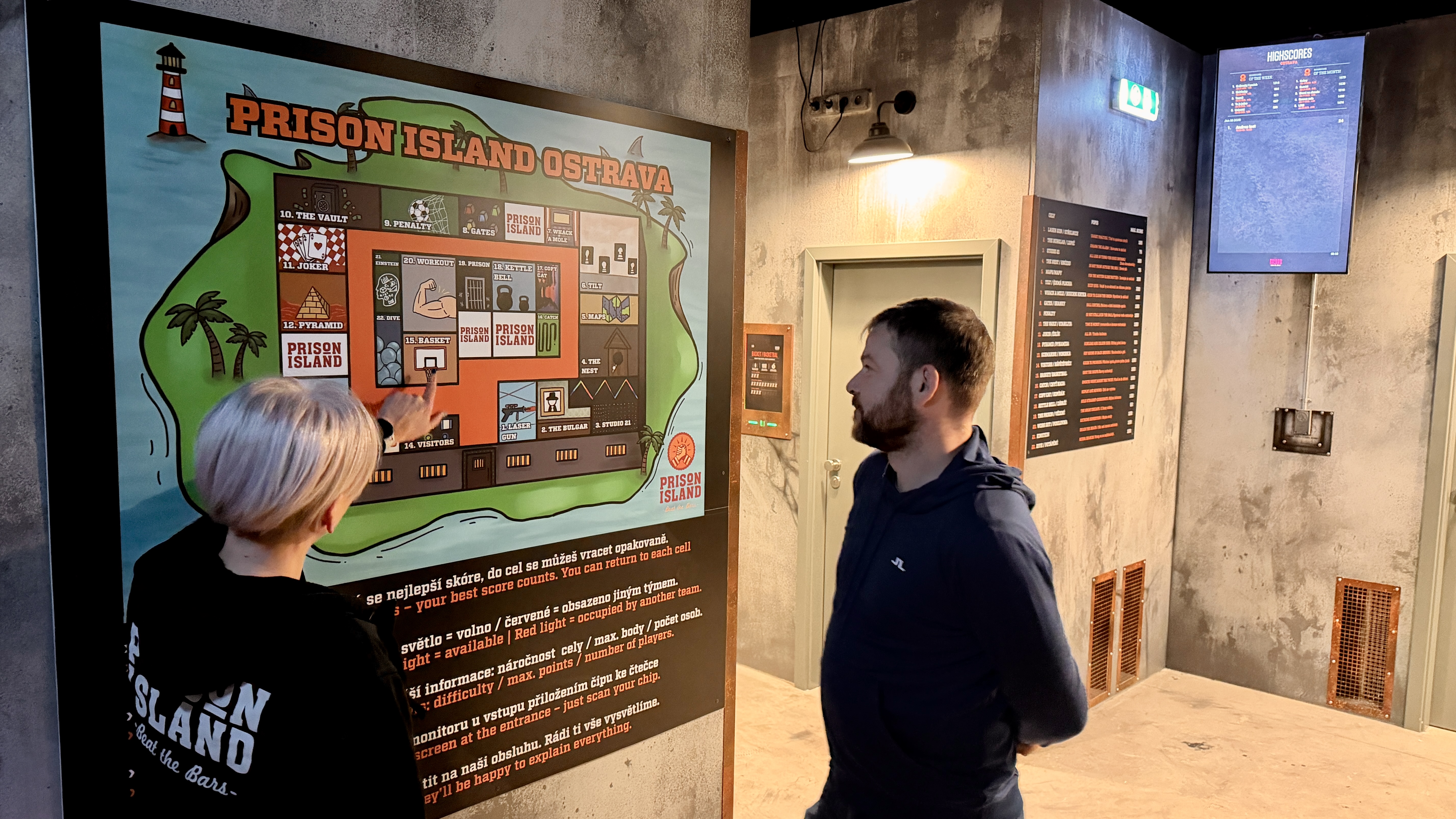 Člen týmu vysvětluje návštěvnici hru PRISON ISLAND