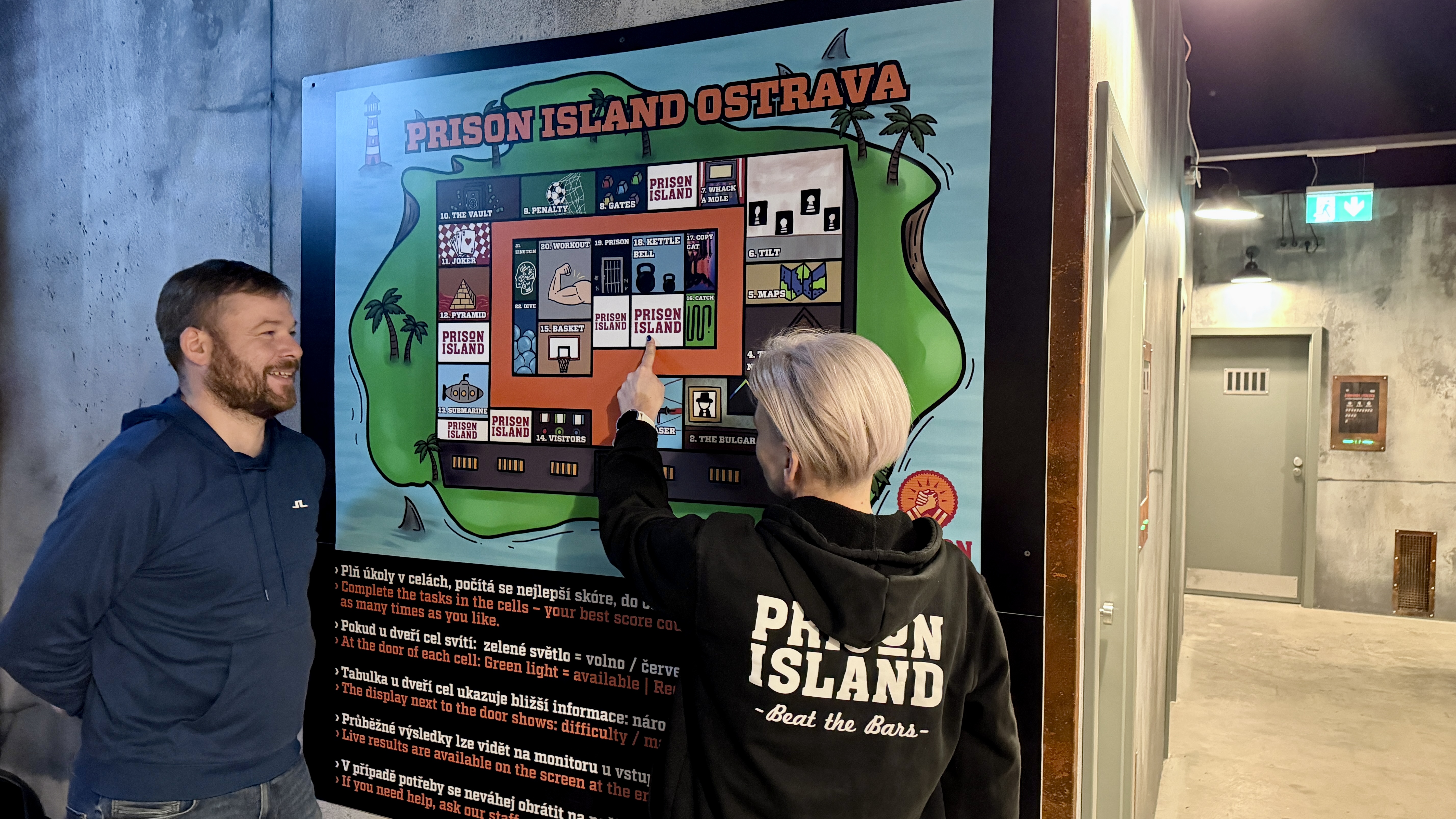 Člen týmu vysvětluje návštěvnici hru PRISON ISLAND